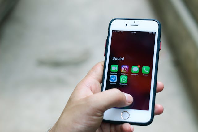 A person holding a cell phone with a social media app on it, symbolizing the impact of a viral post or trend